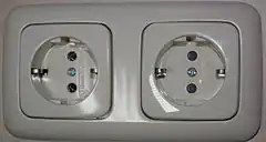 Schuko socket-outlets manufactured by Busch-Jaeger Elektro, RH socket has protective shutters, LH  does not