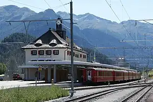 Three-story building with hip roof and adjoining canopy-covered platforms