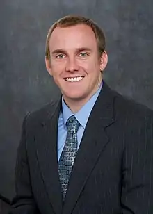 Image of man in his thirties in a business suit, smiling at the camera