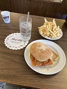 A photograph of a meal, with a cheeseburger towards the center