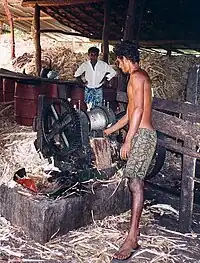 Two men use industrial machinery