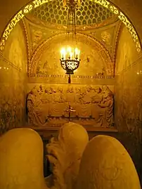 Angel praying towards relief of the Last Supper in the baptismal chamber north of the altar.