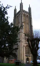 Decorated and buttressed yellow stone tower.