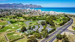 An aerial view of Strand with the Coast Road and Strand Golf Club in the foreground.