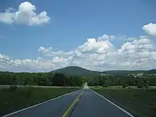 View of a long paved road and a mountain in the distance.