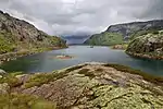 A lake surrounded by forest and hills