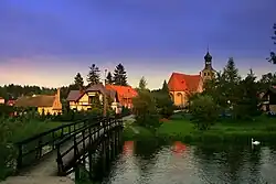 View of Swornegacie with the Brda River in the foreground and the Saint Barbara church in the background