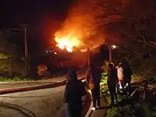 People watching the Tapu Te Ranga fire with fire hoses next to them