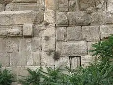 Large stones in a wall with a straight joint running vertically between masonry of two distinctive types