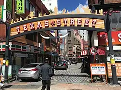 An entrance to the street, with a recent sign installed as part of renovation efforts (2018)