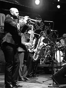 Guy playing trumpet in black and white.