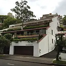 View of white brick apartment building with terracotta roofs.