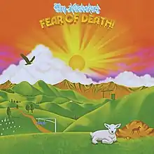 A pastoral painting with a lamb lying down in the grass, the sun setting over a mountain, and a bird of prey flying in the sky