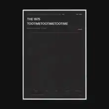 A photo of a gray rectangular box surrounded by a thick black border. Written in the upper left corner of the box are the words "The 1975" and "TooTimeTooTimeTooTime".