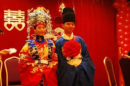 Traditional Chinese wedding ceremony, with a double happiness character in the background