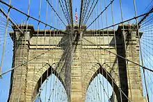 A view of diagonal stays and vertical suspender cables from below. The main cables run at the top.