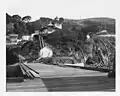 View from pier looking ashore and up at light station – U.S. Coast Guard Archive