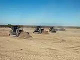 Marine Wing Support Squadron 374 heavy equipment operators remove dirt from and level an unmanned aircraft system runway (2009).