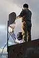 Test services maintenance crewmen weld the support brace of a fake radar dish on the top of a target shaped like a radar van (2010).