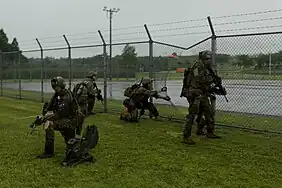 Maritime Raid Force, 31st Marine Expeditionary Unit, provide security outside of a breached fence during a raid