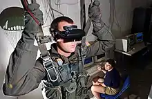 Image 14U.S. Navy Hospital Corpsman demonstrating a VR parachute simulator at the Naval Survival Training Institute in 2006 (from Virtual reality)