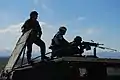 A Macedonian Soldier takes aim during a crew-served weapons range in Macedonia while a U.S. and Macedonian Soldier looks on.