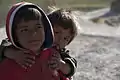 A pair of children gather outside a coordination meeting with village elders in Kajran district, 2011.