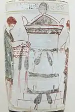 Photograph showing detail from an Athenian vase. A woman leaves a garland on a tomb.