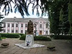 Soviet era memorial to those who perished in World War II in Voynyliv. Building of Professional Technical College of Voynyliv is on the back.