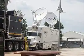 A WWE HD satellite truck in a parking lot.