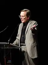 Friedkin speaking at a podium