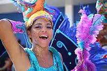 A person dressed in a costume wearing glitter on their face and neck.