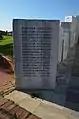 Marble block bearing the names of the victims and tiny holes next to each name to hold a flower