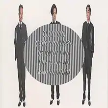 A horizontally compressed photo of the band dressed in suits, with a diffraction grating circle in the middle with the text "Slipping into madness is good for the sake of comparison".