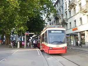 Red-and-cream-colored train in the street