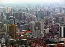 A cityscape of buildings of various heights, seen from above, gradually disappearing into a haze in the background