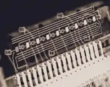 Eight small rectangular blobs, which are the digits, connected by fine hair-like wires to tracks along a circuit board